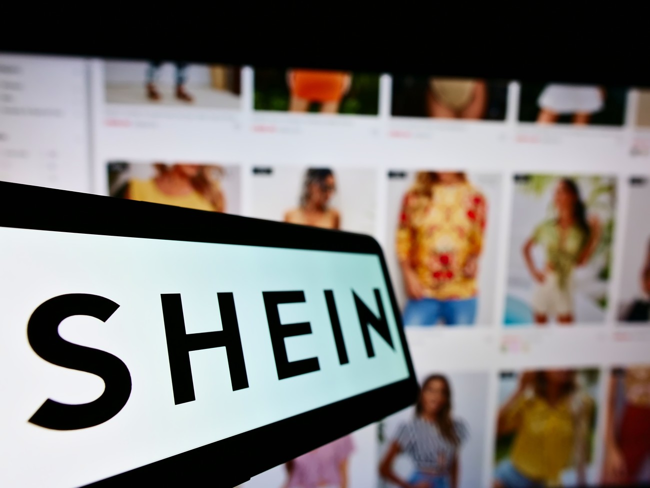 STUTTGART, GERMANY - Aug 14, 2021: Mobile phone with logo of Chinese e-commerce company Shein on screen in front of business website  Focus on center-left of phone display ; Shutterstock ID 2037893222